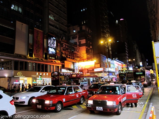 Busy street scene in Mong Kok with pedestrians, shops, and traffic