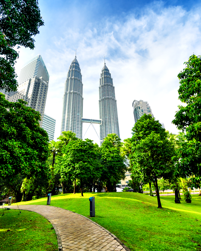 KLCC Park green lawn and walking path with Petronas Twin Towers in background