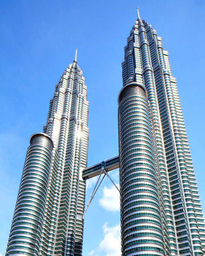 Petronas Twin Towers in Kuala Lumpur viewed from below against blue sky