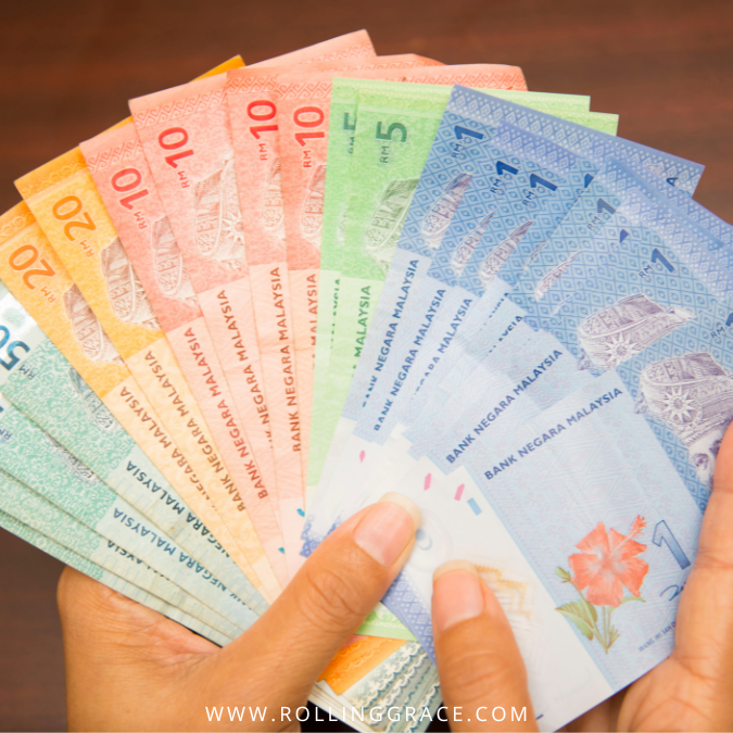 Money Changers in Malaysia: How Exchange Rates Work (2026) 3 Hands holding Malaysian ringgit banknotes at a licensed money changer in Kuala Lumpur