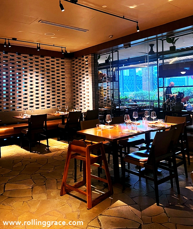 Interior of Osteria Mozza Singapore at Hilton Singapore Orchard with warm lighting and open kitchen