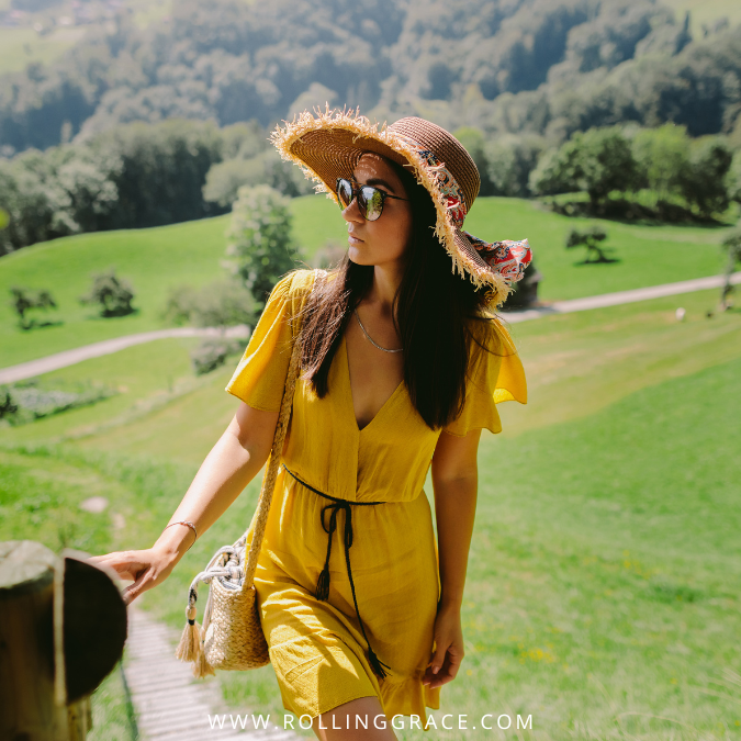 Woman in yellow outfit walking through green landscape, Malaysia dress codes for travellers