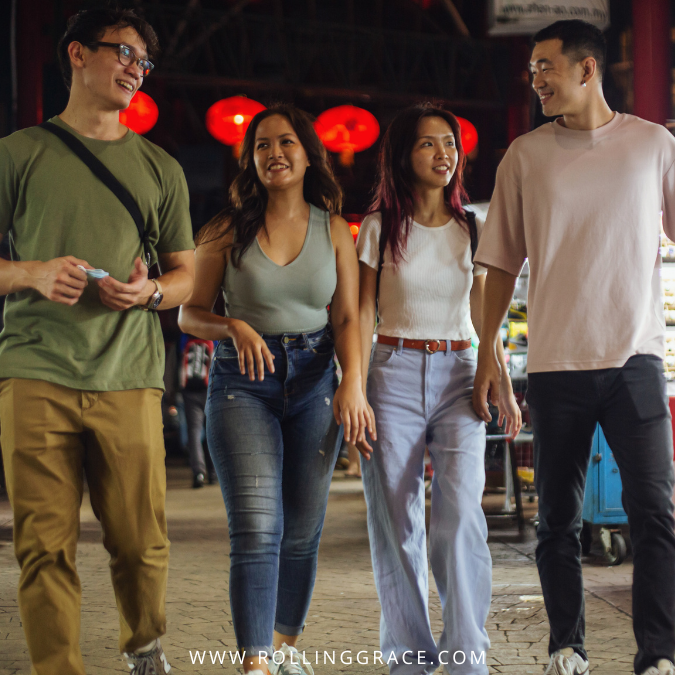 Group of tourists in casual clothing exploring a night market in Malaysia