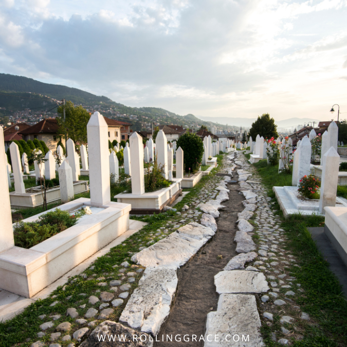 White headstones arranged in long, quiet rows across a hillside cemetery in Sarajevo.