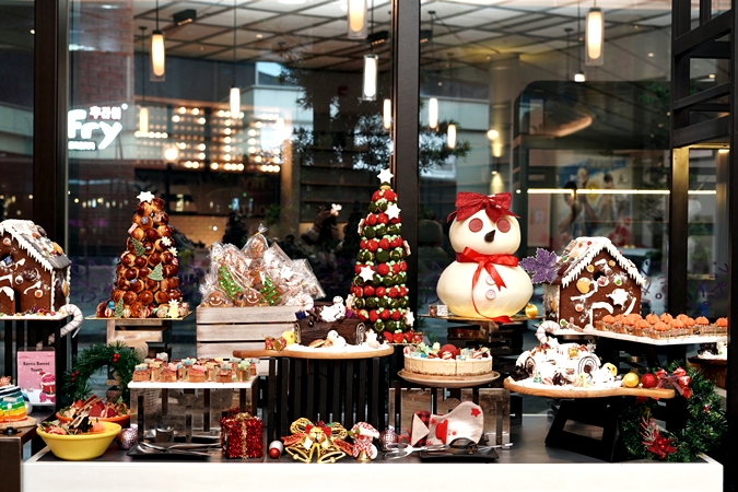 Assorted Christmas desserts at Moxy Putrajaya including cakes, pastries and fruit based sweets on a decorated dessert table.