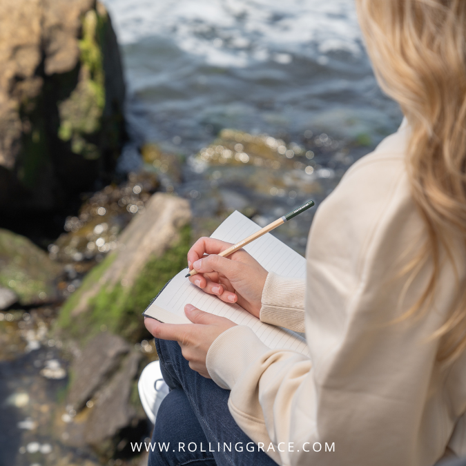 Journalling by the coast as a way of processing travel anxiety symptoms and grounding before a trip.