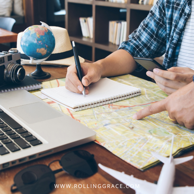 Hands planning a trip with maps and laptop on a desk, travel anxiety treatment through preparation