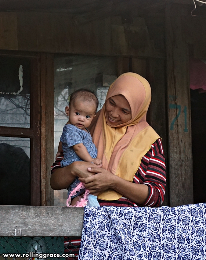 Bajau Laut mother holding a young child at Kampung Mabul village, Pulau Mabul, Sabah