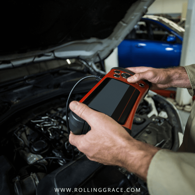 Technician using diagnostic equipment on a car engine at an electric vehicle battery manufacturing plant