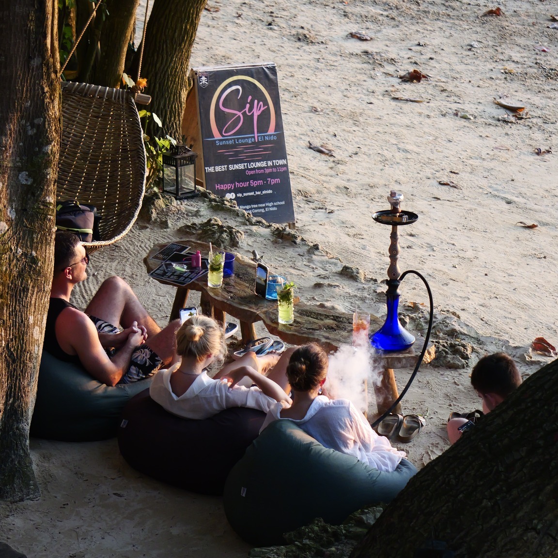 Sip Sunset Lounge El Nido guests relaxing on bean bags at sunset