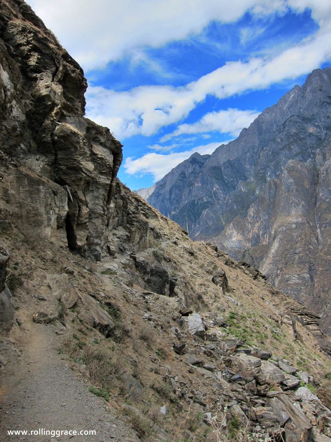 Waterfall cascading down rocky cliffs beside the Tiger Leaping Gorge hiking trail, Yunnan
