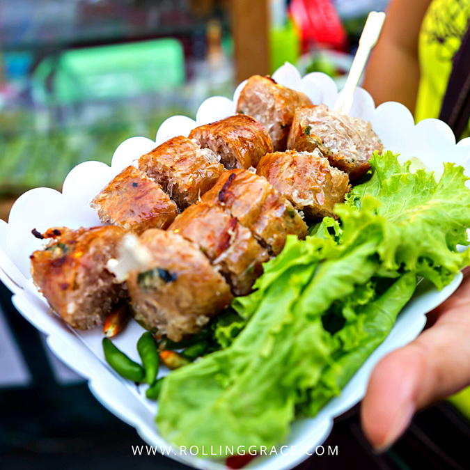 Grilled sai krok isan fermented sausages served with raw cabbage, ginger, and chillies in Chiang Mai