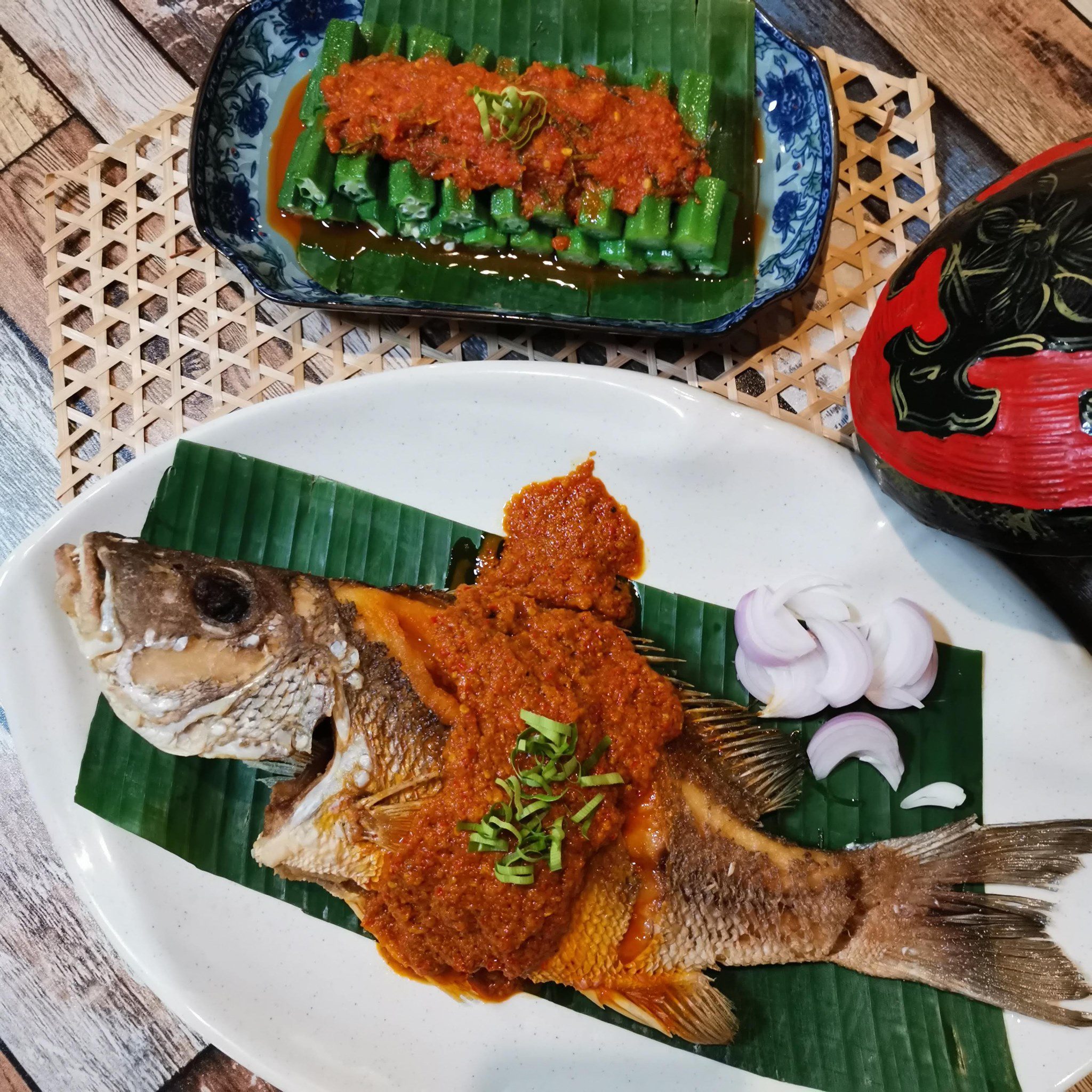 A whole steamed fish topped with spicy sambal and a side of okra at Atlantic Nyonya Melaka