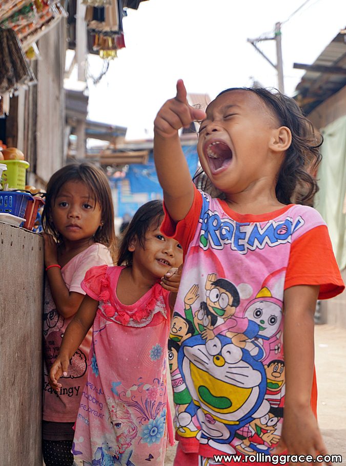 Bajau Laut children playing and watching a kite fly at Pulau Mabul Sabah Malaysia