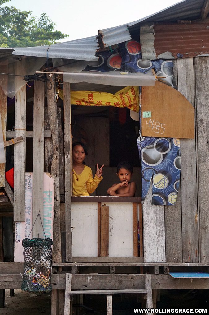 Bajau Laut mother and children at wooden stilt house doorway Pulau Mabul Sabah