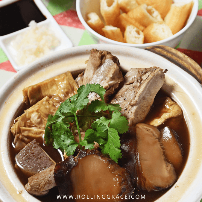 Clay pot of bak kut teh with pork ribs, tofu puffs, and mushrooms in dark herbal broth at Klang, Selangor