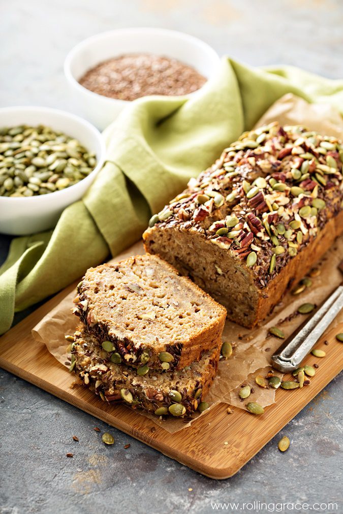 Sliced loaf of homemade multi-seed bread with chia seeds visible through the crumb on a wooden board