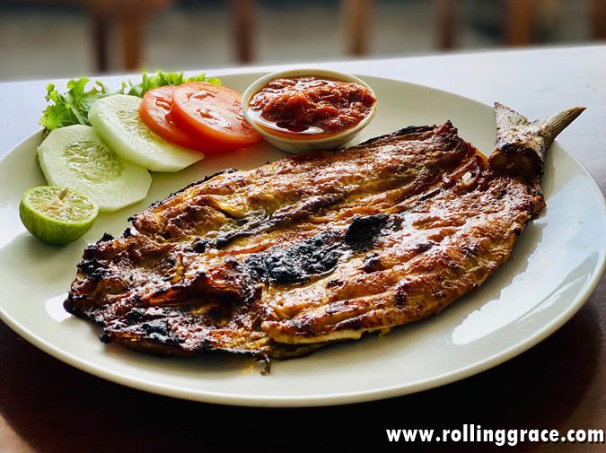 Ikan bakar grilled fish marinated in spices and cooked in banana leaf, served with sides in Penang