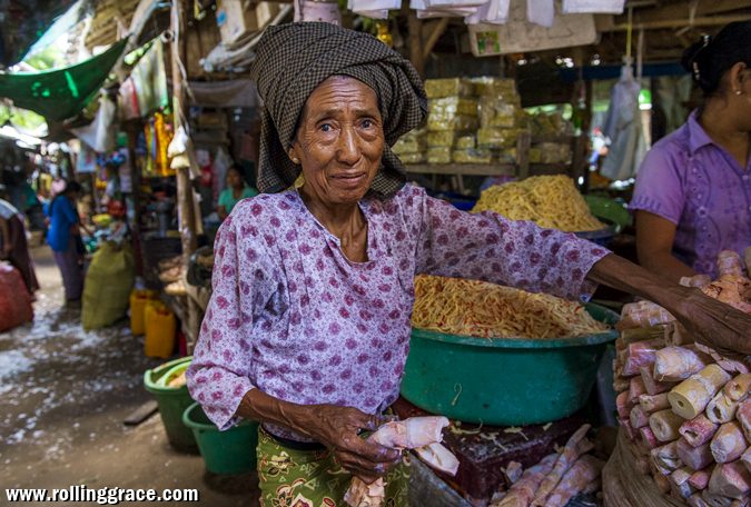 Elderly Myanmar woman selling goods at a traditional street market