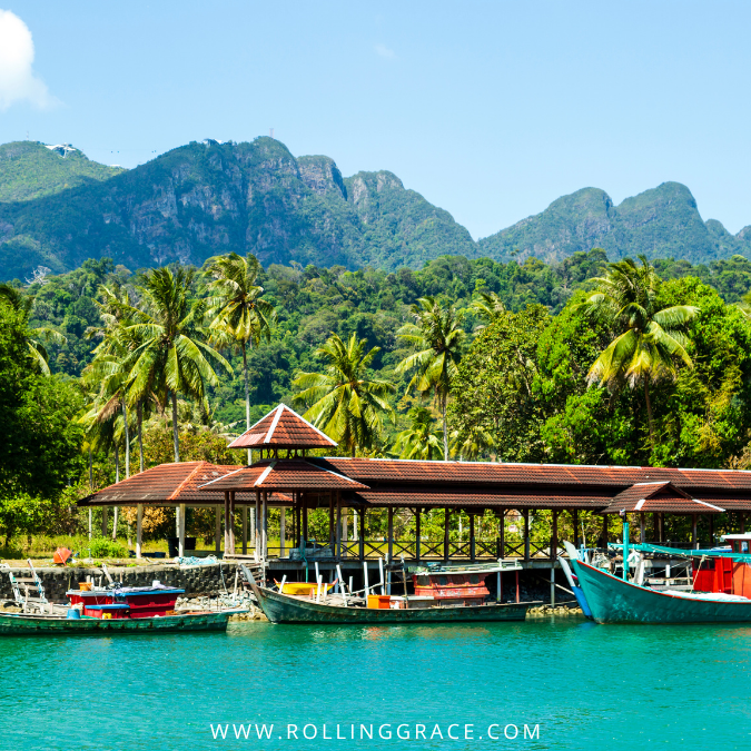Colourful fishing boats moored in turquoise water at Pulau Tuba, a traditional Malay village near Langkawi