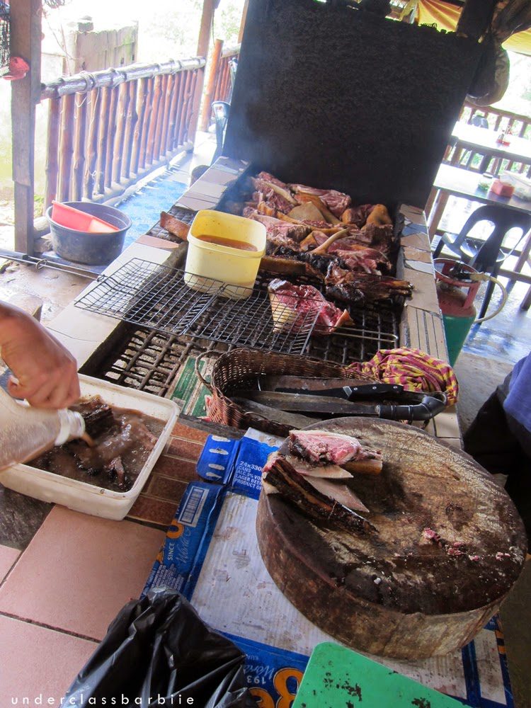 Raw wild boar cuts laid out on a grill at a Sinalau Bakas stall, Sabah Malaysia