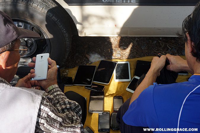 Used mobile phones, gadgets, and electronic items spread on the ground at the Nat Pokok Getah flea market in Perlis