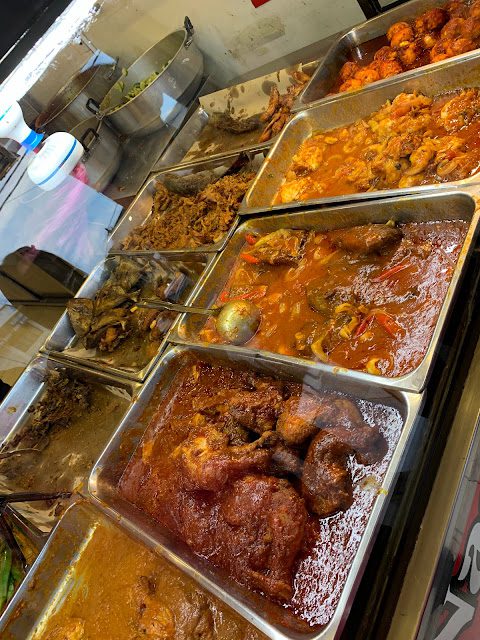 Trays of nasi kukus dishes including ayam berempah and curry at Warisan Nasi Kukus Kota Bharu Kelantan