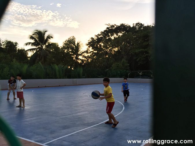 Children playing basketball outdoors in the lanes of Bagan Hailam fishing village, Port Klang, Selangor, Malaysia.