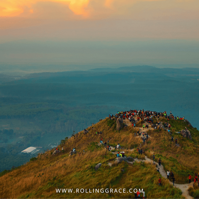 Golden sunrise over Bukit Broga hilltop with a crowd of hikers and a sea of clouds filling the valley below