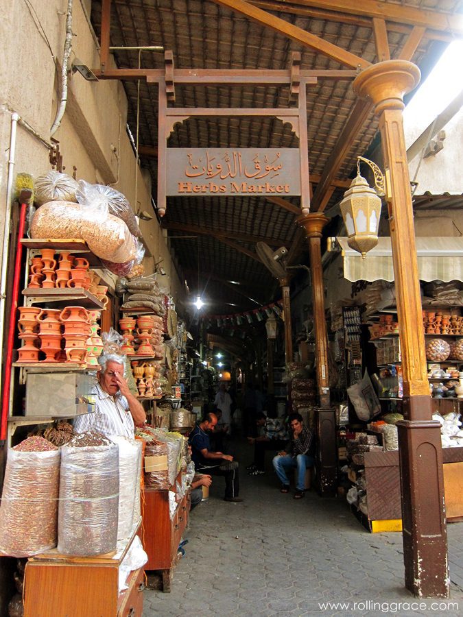Narrow covered alleyway lined with traders and goods at the traditional Deira souk, Dubai.