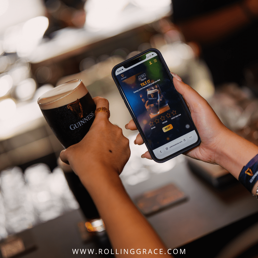 Hand using the Rate Your Pint app at a bar next to a Guinness Draught pint, Malaysia