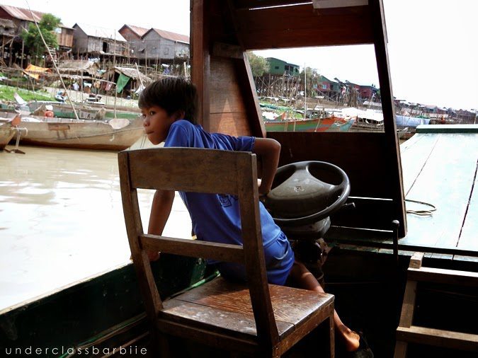 1-Day Kampong Khleang Itinerary: Best Attractions & Tips 10 Young child steering a wooden boat on Tonle Sap at Kampong Khleang, Cambodia
