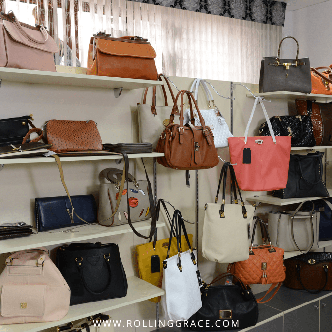 Handbags and leather goods displayed on shelves inside a shop at Karama Market, Dubai.