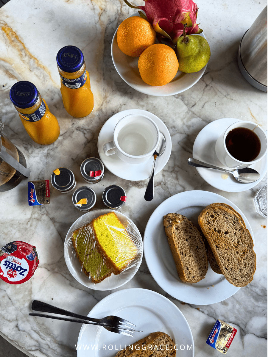 Breakfast spread with bread, fruit, juice and coffee on a wooden table at Bon Ton Resort, Langkawi, Malaysia