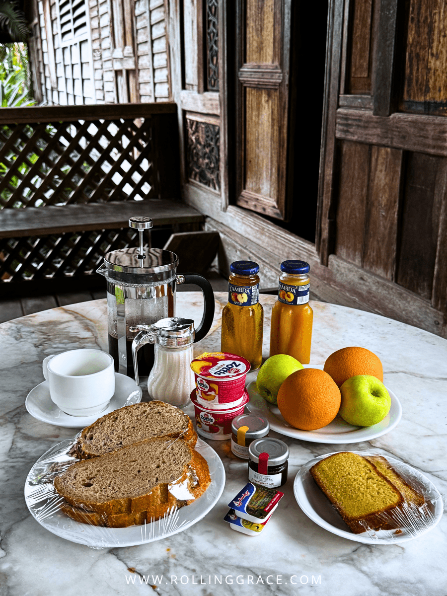 Villa breakfast basket with homemade bread, fruit, juice and spreads on a wooden verandah at Bon Ton Resort, Langkawi, Malaysia