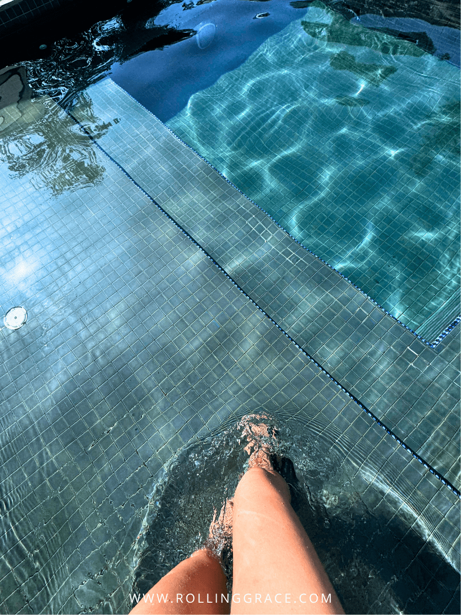 Clear blue swimming pool with a foot dipping in at Bon Ton Resort, Langkawi, Malaysia