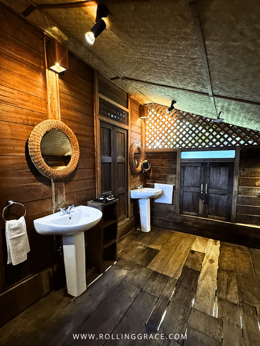 Open-plan bathroom with pedestal sink and dark timber floors inside a heritage villa at Bon Ton Resort, Langkawi, Malaysia