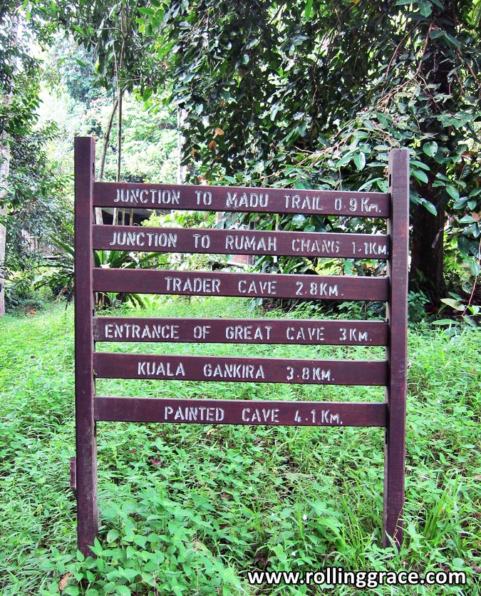 Wooden signboard showing trail distances to Trader's Cave, Great Cave and Painted Cave at Niah National Park