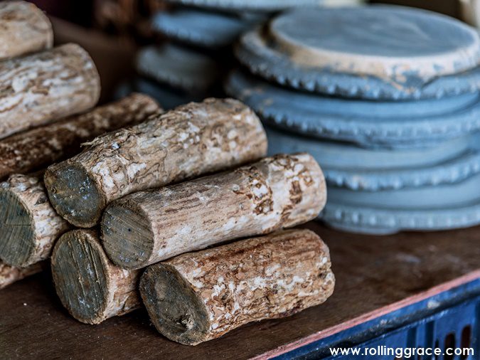 Thanaka bark logs and circular kyauk pyin grinding stones for sale at a market in Myanmar