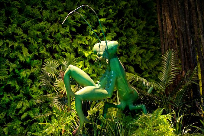 Animated green creature display from Jungle Jive or Dino World zone at Wetland Studios Putrajaya life-sized animatronic reptile exhibit for family attractions