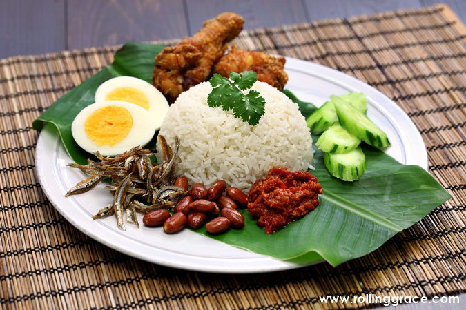 Nasi lemak on banana leaf with sambal anchovies peanuts egg and cucumber, the national dish and most famous of all Malaysian rice dishes