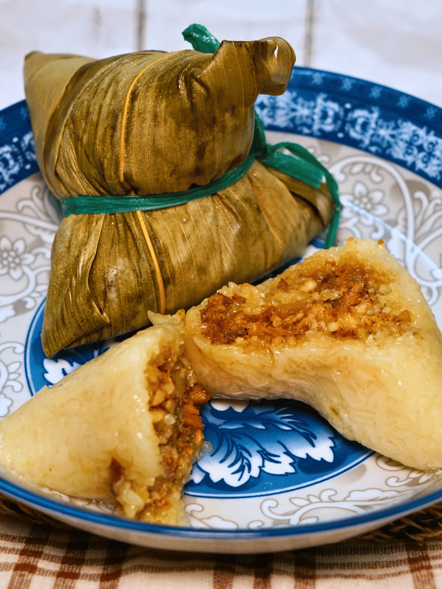 Zong zi Chinese glutinous rice dumplings wrapped in bamboo leaves on a decorative plate, a traditional Malaysian rice dish
