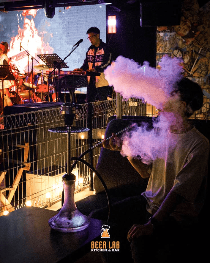 10 Best Shisha in Penang: Exciting Island Hookah Experience 10 Guest exhaling shisha smoke at a live music night at Beer Lab in George Town Penang