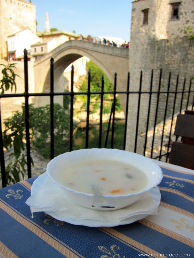 Bowl of Begova Čorba chicken and okra soup with a view of Mostar