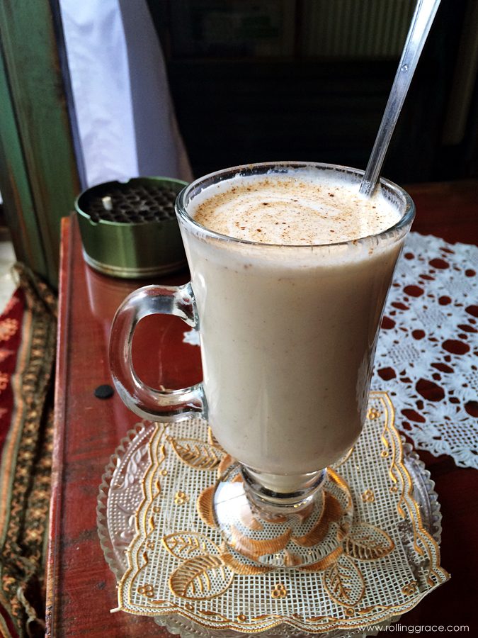 A tall glass of warm frothy salep drink dusted with cinnamon in Bosnia