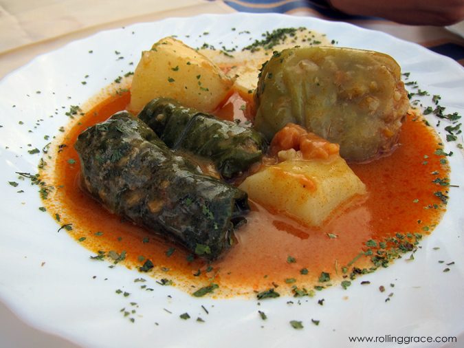 Platter of Bosnian stuffed vegetables including peppers and rolled leaves in sauce