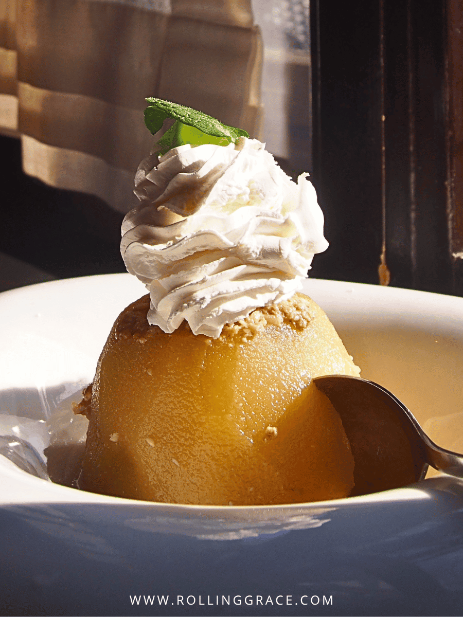 Tufahija, a walnut-stuffed poached apple topped with whipped cream in a glass