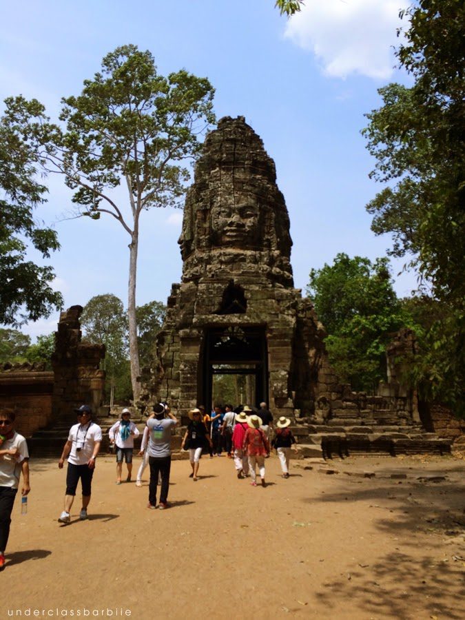 12 Best Temples in Siem Reap You Have to See 6 Visitors walking through a stone gateway at Ta Prohm Temple in Siem Reap Cambodia