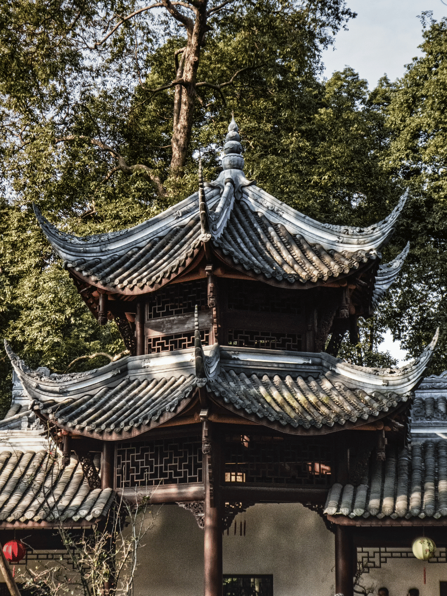 7 Stunning Things to See at Du Fu Thatched Cottage Chengdu 6 Traditional Chinese pagoda with curved grey roof surrounded by trees in the park at Du Fu Thatched Cottage Chengdu