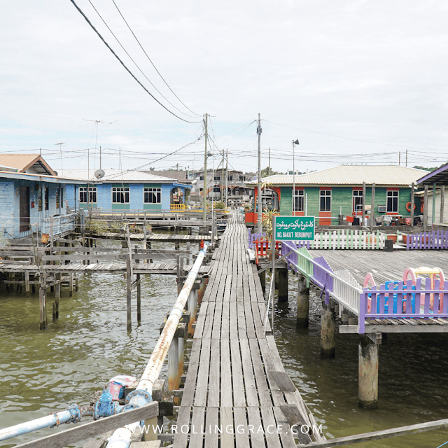 7 Best Things to Do at Kampong Ayer Brunei Water Village 5 Wooden boardwalk with power lines running between colourful stilt houses at Kampong Ayer Brunei